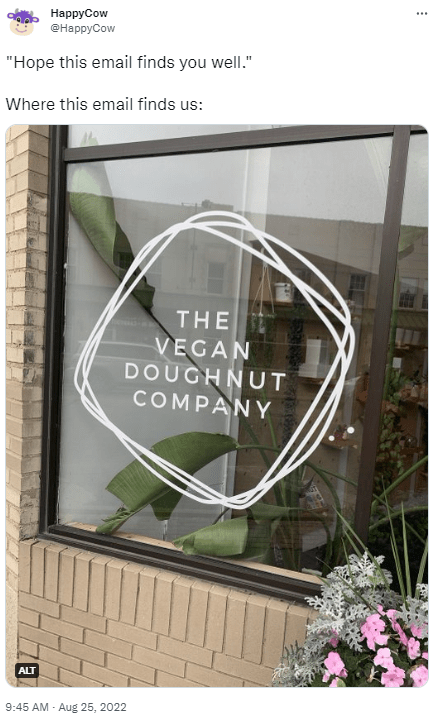 A tweet from HappyCow that reads "'Hope this email finds you well.' Where this email finds us:" and includes a photo of the exterior of The Vegan Doughnut Company.
